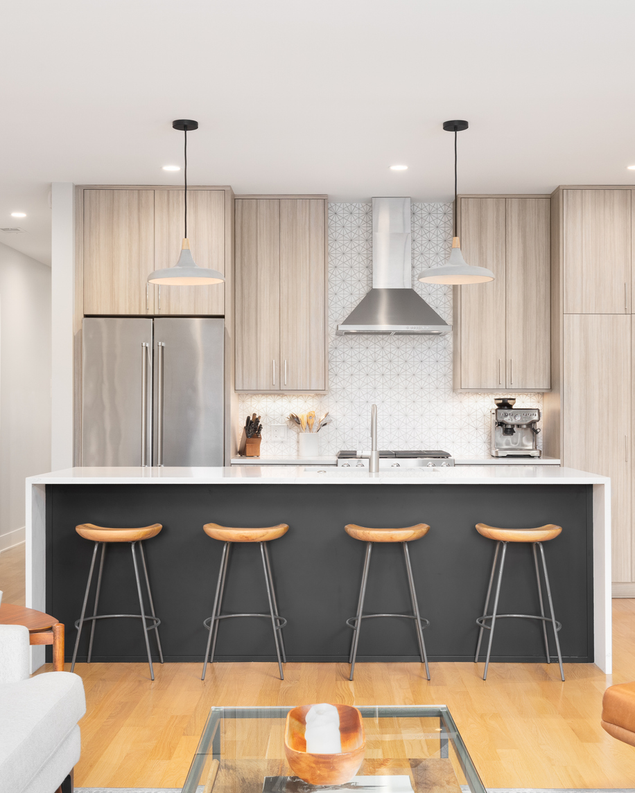 Modern kitchen with dark island and light wood cabinets